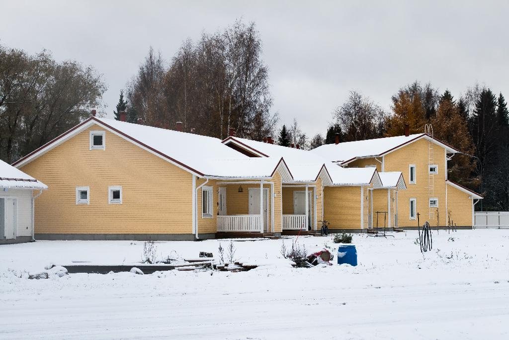 Butter-yellow family home with white trim set in fresh winter snow