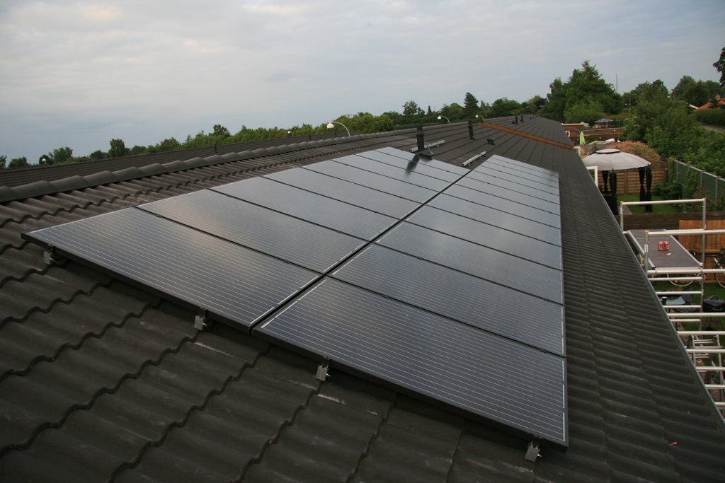 Dark solar panels mounted neatly on a tiled roof